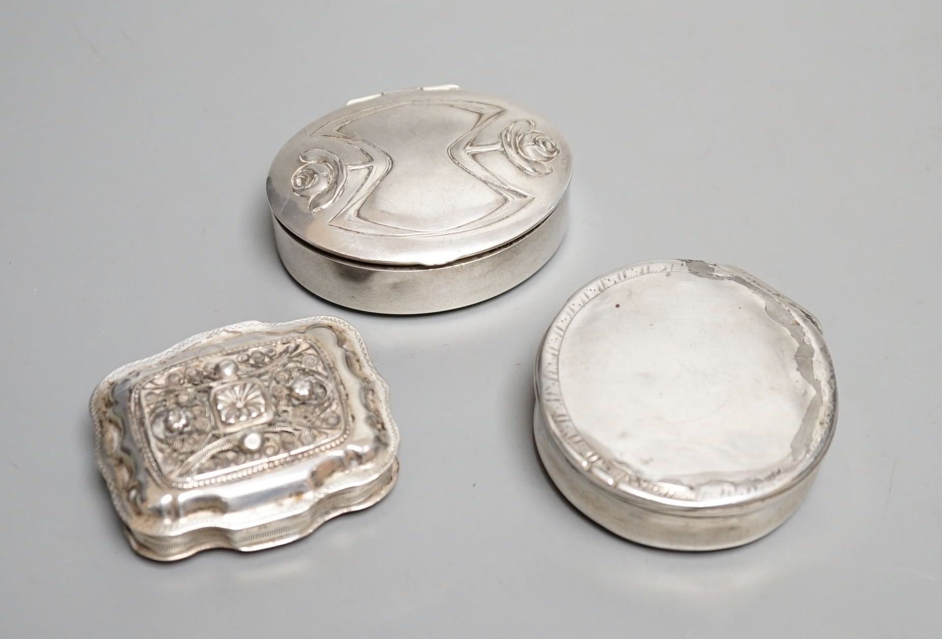 Three assorted continental white metal pill boxes including Dutch with filigree panel and German, largest 66mm.